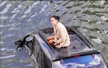 "2020-й, запалюй": фото дівчини на даху затопленого автомобіля в Харкові розлетілося на меми (відео)