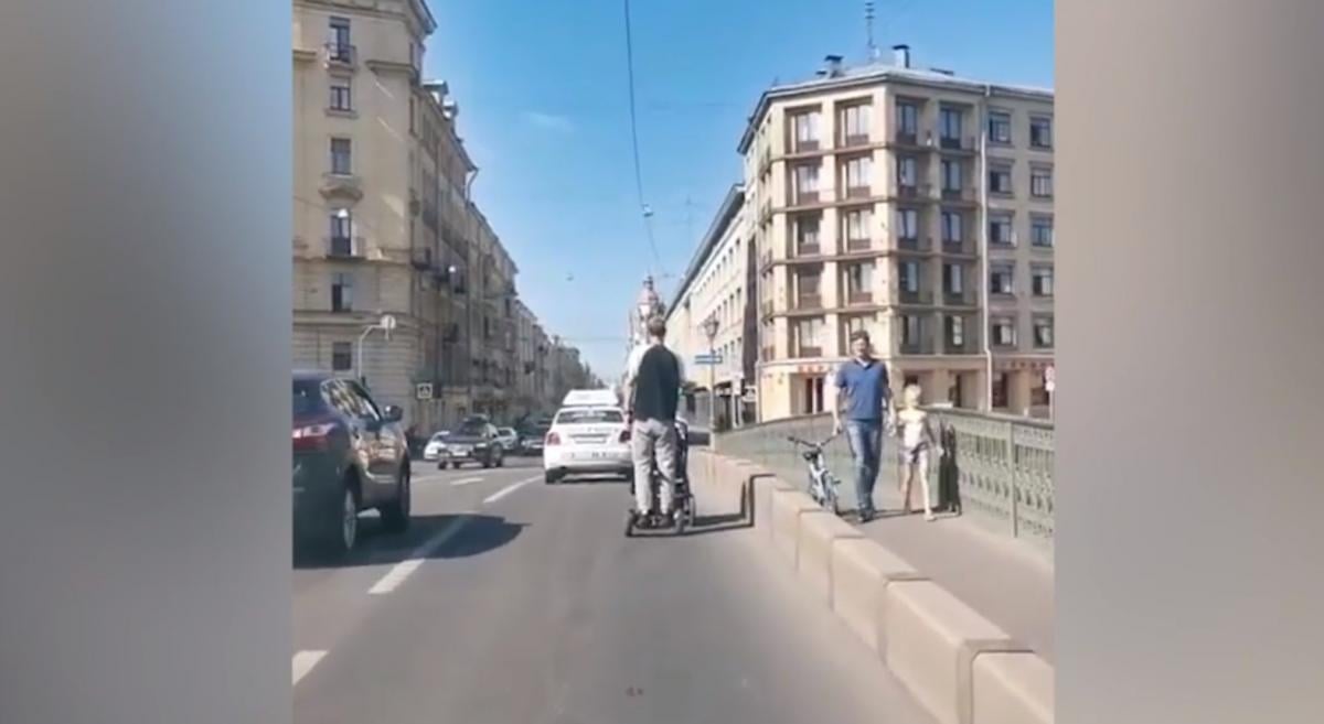 Чоловік безтурботно віз коляску дорогою / скріншот з відео Чоловік безтурботно віз коляску дорогою / скріншот з відео