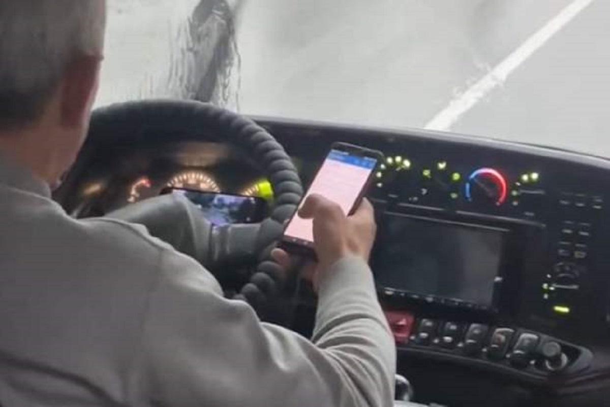 На кадрах видно, как мужчина не держит руль, зато держит в правой руке смартфон, затем берет в левую кнопочный телефон, а перед ним лежит еще один включенный смартфон / скриншот