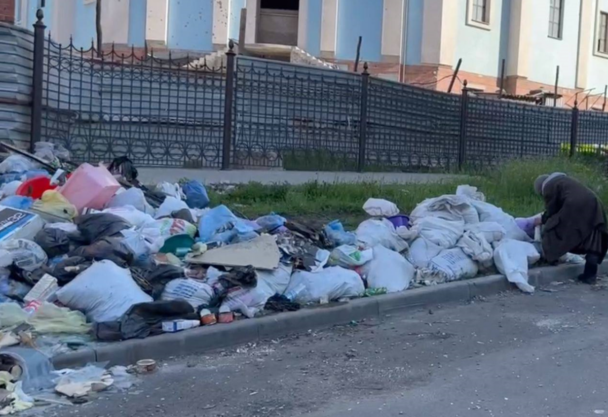 Некоторым жителям Мариуполя приходится искать еду в мусорниках / фото Петр Андрющенко 