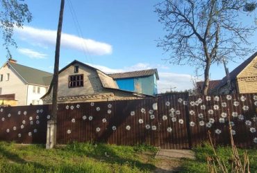 Незламна нація: у Гостомелі мешканці перетворили дірки від куль у паркані на квітки (фото)