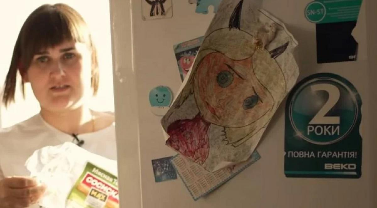 Пользователи обратили внимание на кадр, на котором показаны родственники Василенко на фоне холодильника с надписью на украинском языке / Скриншот Пользователи обратили внимание на кадр, на котором показаны родственники Василенко на фоне холодильника с надписью на украинском языке / Скриншот