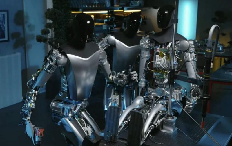 Два робота-гуманоида Tesla Optimus собирают третьего / Скриншот Два робота-гуманоида Tesla Optimus собирают третьего / Скриншот