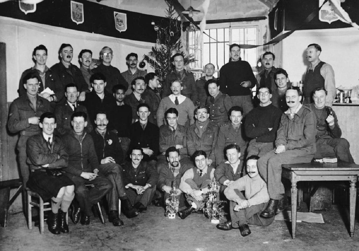 Британці у німецькому полоні позують на тлі різдвяної ялинки / Фото: Imperial War Museums. Британці у німецькому полоні позують на тлі різдвяної ялинки / Фото: Imperial War Museums.