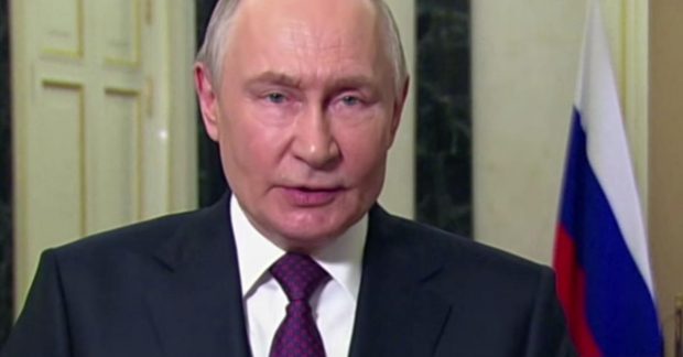 президента РФ зустрічала група людей з прапорами та вітальними словами